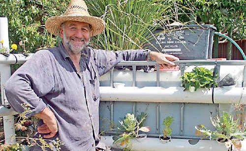 Wayne Wadsworth with his aquaculture tank in the backyard of the Reversing Greenhouse House in Goonellabah. Wayne Wadsworth with his aquaculture tank in the backyard of the Reversing Greenhouse House in Goonellabah.